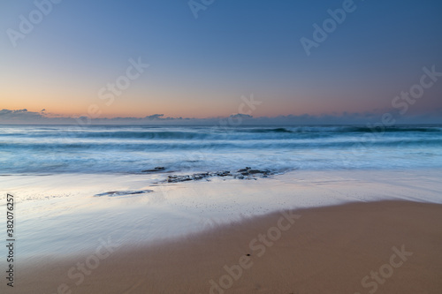 Soft and pretty blue winter sunrise seascape with fog on the horizon