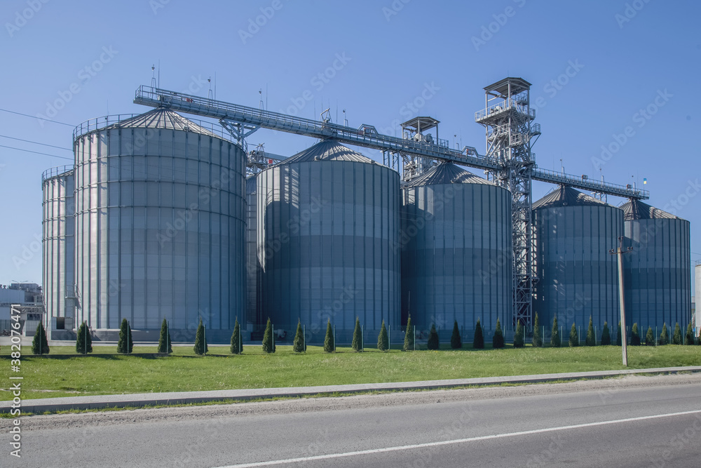 Granary. A large modern agro-processing plant for the storage and processing of grain crops. Large metal barrels of grain. Granary elevator. Horizontal image.