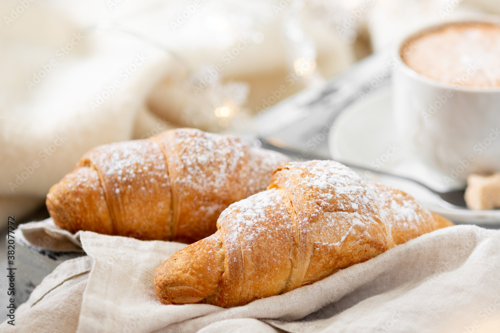 Croissants. Croissants and cappuccino on a wooden tray on a light background. French Breakfast in bed. Croissants close up Croissants. Croissants and cappuccino on a wooden tray on a light background. French Breakfast in bed. Croissants close up