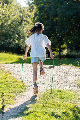 真夏の公園で縄跳びをしている可愛い子供