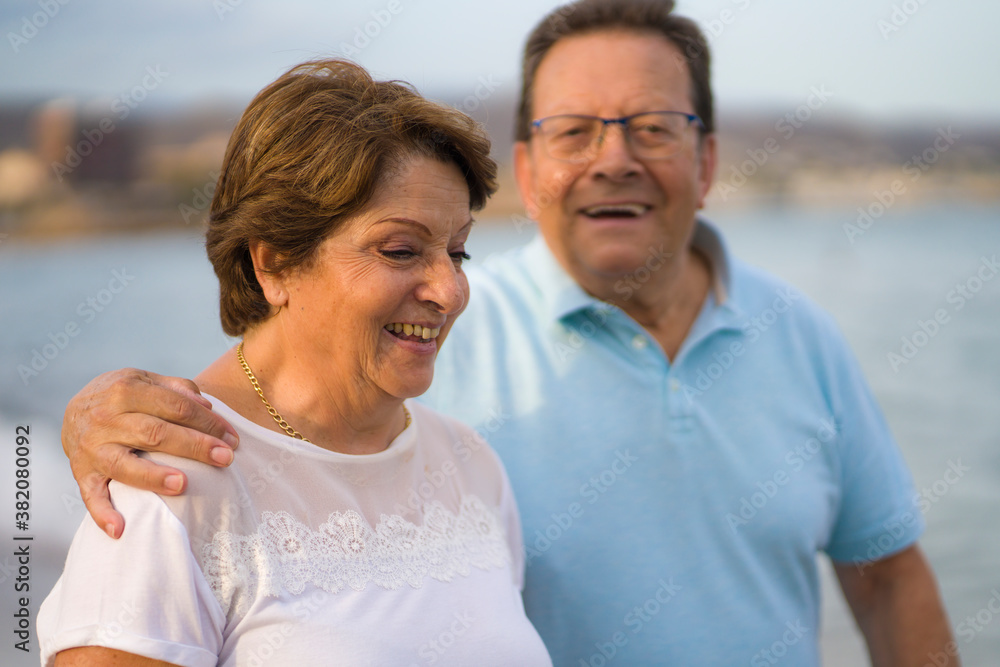 happy retired mature couple walking on the beach - pensioner woman and her husband taking romantic walk together enjoying sweet holidays in lifetime relationship and love happy retired mature couple walking on the beach - pensioner woman and her husband taking romantic walk together enjoying sweet holidays in lifetime relationship and love
