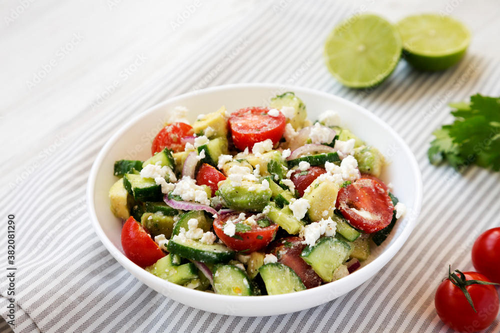 Delicious Avocado Tomato and Cucumber Salad in a bowl, low angle view. Delicious Avocado Tomato and Cucumber Salad in a bowl, low angle view.