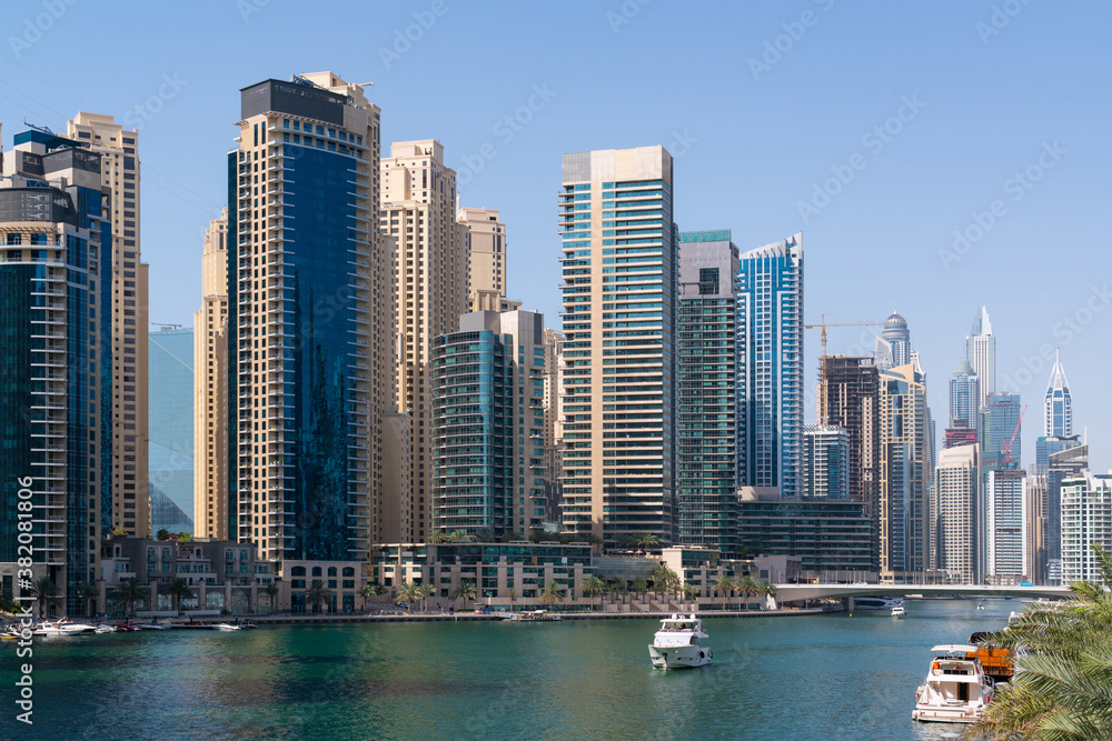 Fototapeta premium Panoramic view of skyscrapers of Dubai Marina at a sunny day. Modern cityscape of the capital of the Emirate of Dubai. Business hub of international trading and financial services of Western Asia