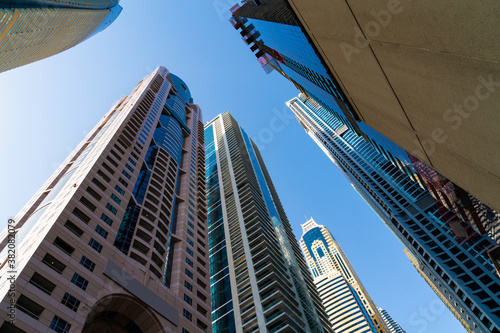 Low angle shot of skyscrapers of financial district of Dubai  UAE at a sunny day. Futuristic low-angle view of the capital of the Emirate of Dubai. A center for international trading of Western Asia.