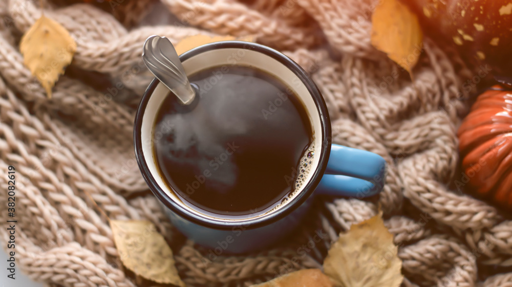 Autumn background with dry leaves, blue cup of coffee. Knitted background, pumpkins, October, November. Autumnal atmosphere. Autumn season. Autumn background with dry leaves, blue cup of coffee. Knitted background, pumpkins, October, November. Autumnal atmosphere. Autumn season.