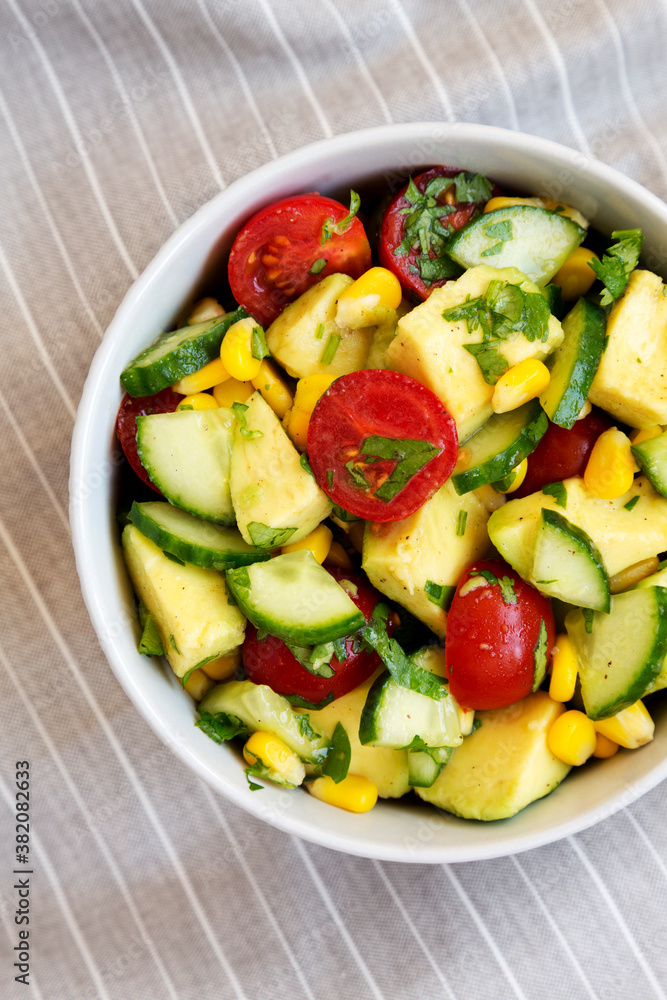Fresh Avocado Tomato Salad in a bowl, top view. Flat lay, overhead, from above.