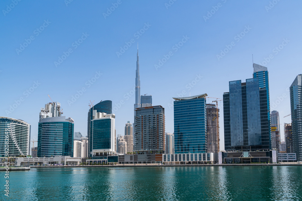 Fototapeta premium Panoramic view of skyscrapers of downtown of Dubai, UAE at Dubai Canal, Business Bay. Modern cityscape of the capital of the Emirate of Dubai. A center of new financial tech of Western Asia