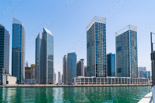 Panorama of skyscrapers of downtown of Dubai, UAE at a sunny day at Dubai Canal, Business Bay. Modern cityscape of the capital of the Emirate of Dubai. A center of new tech of Western Asia
