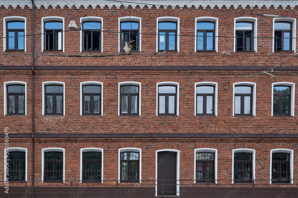 Red brick wall, white frames and glass windows