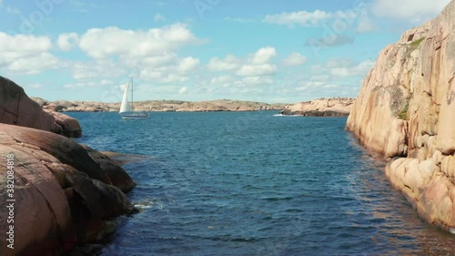 Sailing boat in Sweden between granite stone cliffs and island. Summer boat weather perfect wind for ocean activity. west coast seashore of Sweden close to Gothenburg photo