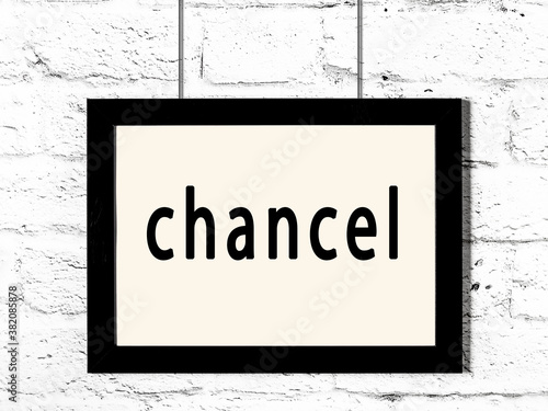 Black frame hanging on white brick wall with inscription chancel