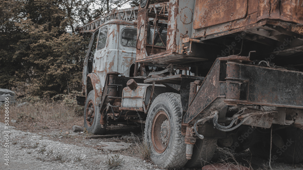 Old, rusty, abandoned truck crane in the woods. Old, rusty interior elements, controls and indicators.