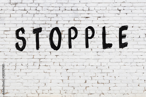 White wall with black paint inscription stopple on it