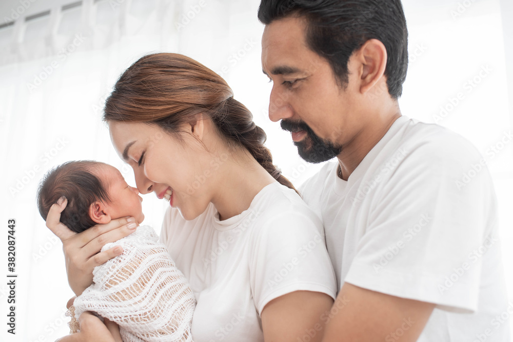 smiling mother and father holding their newborn baby at home..portrait of happy family at home, young parents holding on hands little sweet newborn baby, love and happiness concept. smiling mother and father holding their newborn baby at home..portrait of happy family at home, young parents holding on hands little sweet newborn baby, love and happiness concept.