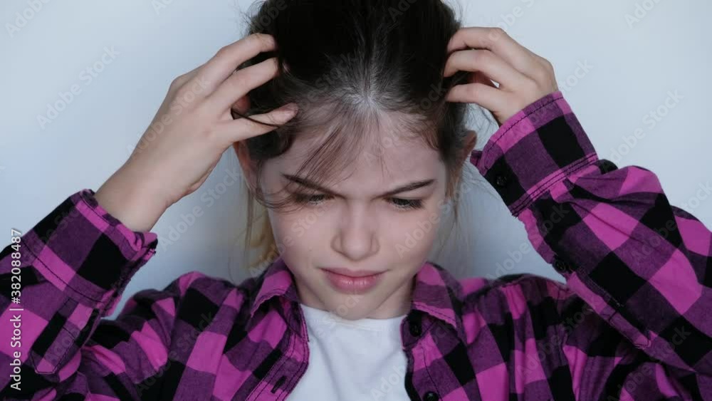 the girl is crying, grabbed her head, a child’s problems. The girl scratches her head, severe itching, infection with lice, allergy the girl is crying, grabbed her head, a child’s problems. The girl scratches her head, severe itching, infection with lice, allergy