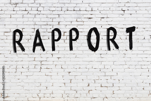 White wall with black paint inscription rapport on it