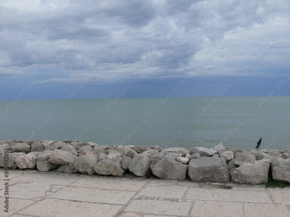 scorcio dell'orizzonte marino dopo una tempesta dalla scogliera lungomare città di caorle venezia italia