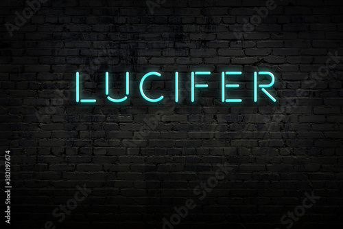 Fotografie Neon sign. Word lucifer against brick wall. Night view