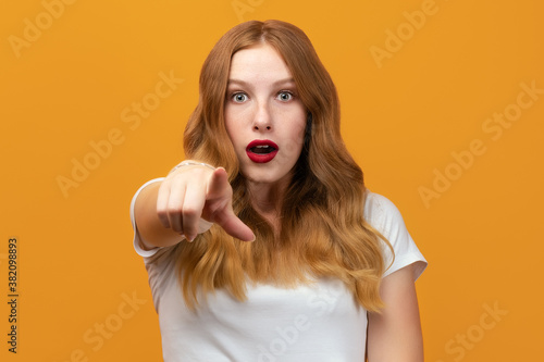 Pretty Young woman looking at the camera and pointing at you