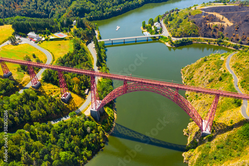 Scenic drone view of parabolic arched framework of railway bridge Viaduc de Garabit across river Truyere near Ruynes-en-Margeride in Auvergne, France..