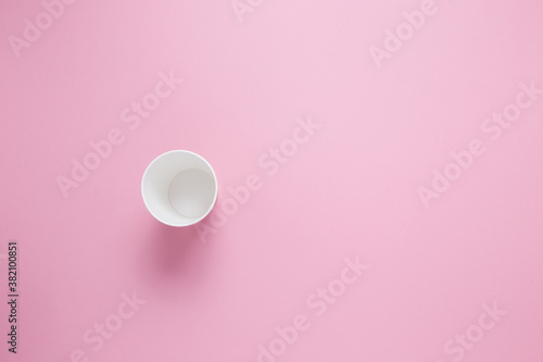 Paper cup for hot coffee or tea on a pink isolated background.