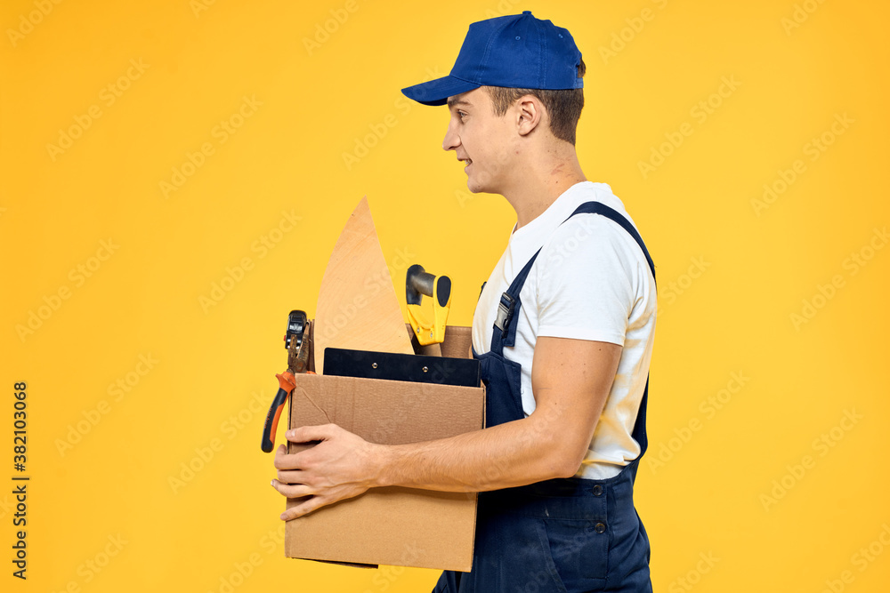 worker with box in hand tools loader yellow background worker with box in hand tools loader yellow background