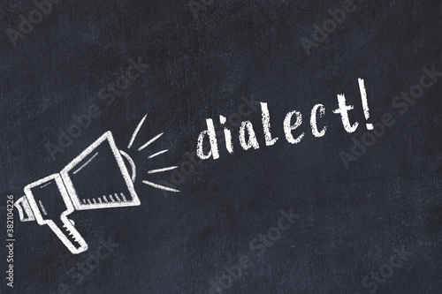 Chalk loudspeaker and inscription dialect on black chalkboard