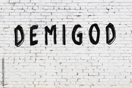 Canvas Print White wall with black paint inscription demigod on it