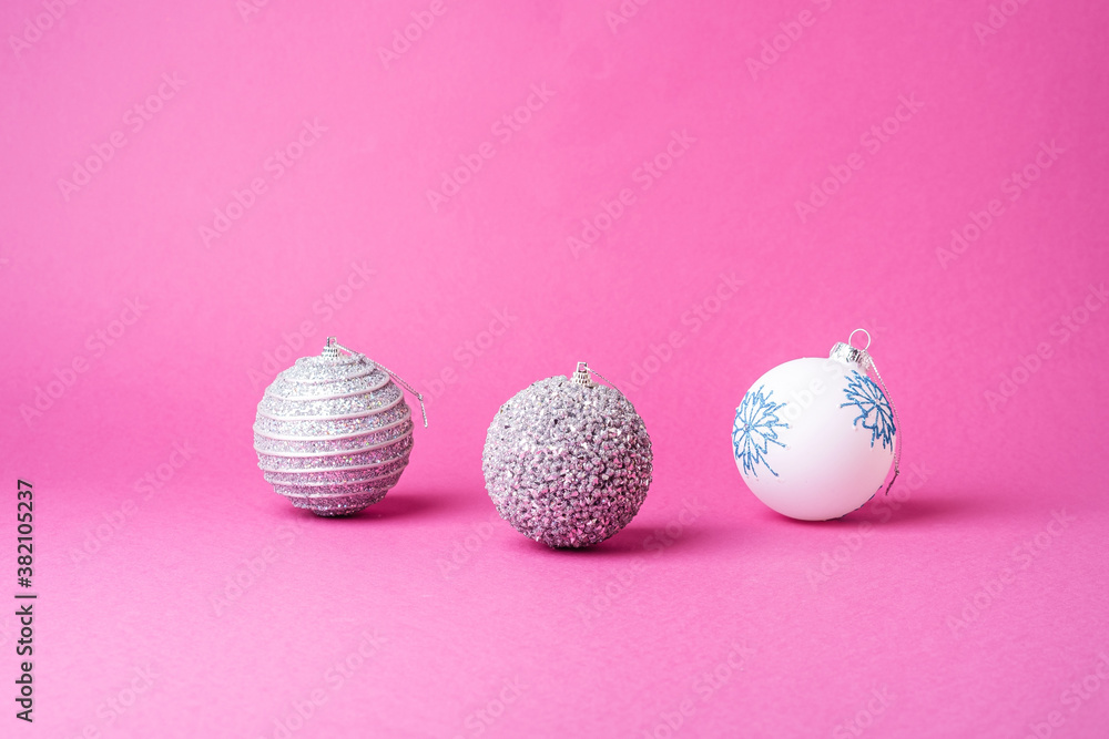 Christmas New Year composition. Gifts, silver and white ball decorations on pink background. Winter holidays concept. Angle view Christmas New Year composition. Gifts, silver and white ball decorations on pink background. Winter holidays concept. Angle view