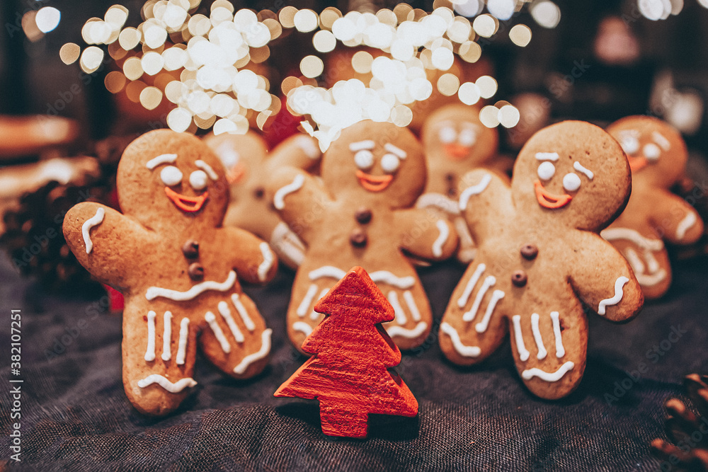 selective focus, vintage effect: Celebrating Christmas and New Year, a group of gingerbread men gathered in front of a Christmas tree