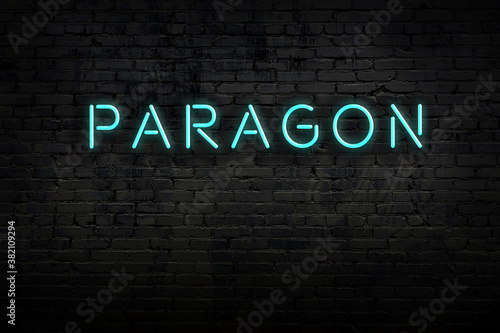Night view of neon sign on brick wall with inscription paragon photo