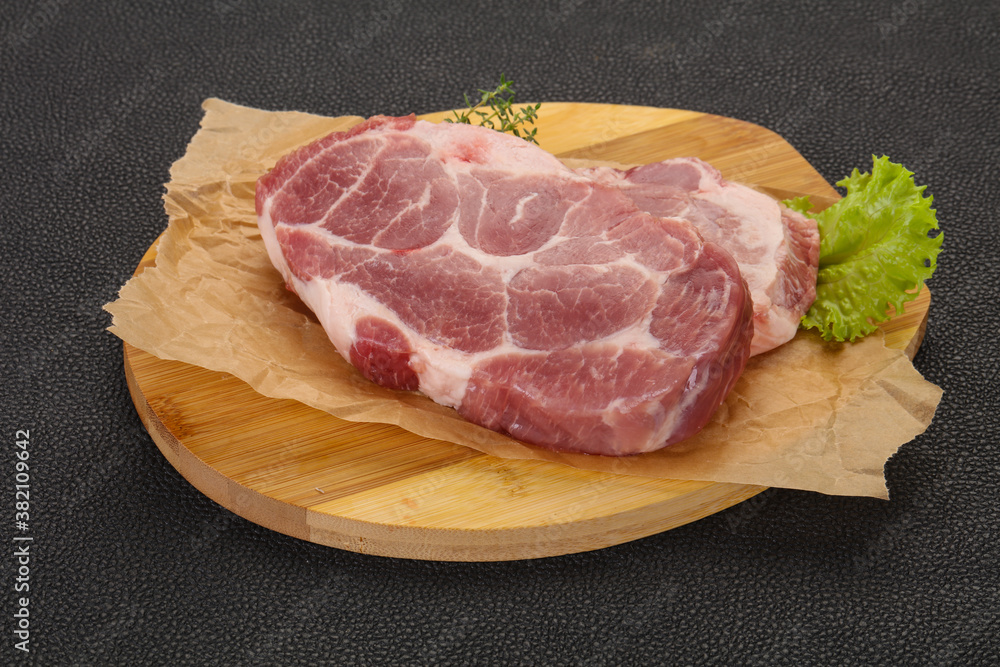Raw pork steak over wooden board Raw pork steak over wooden board