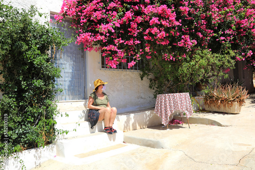 mujer turista con mascarilla sentada debajo de la buganvilla almería 4M0A0463-as20 photo