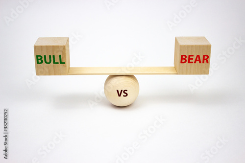 Bull vs bear lettering on wooden cubes scales on a white background. The concept of exchange trading of buyers and sellers. Balance of bulls and bears on the stock exchange.