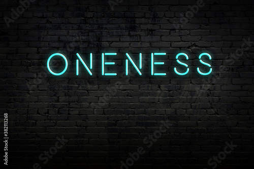 Fotografija Neon sign. Word oneness against brick wall. Night view