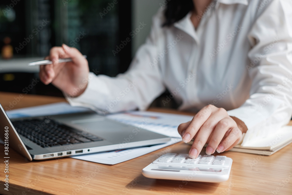 Business accounting, Businessman using calculator with budget document, computer laptop and in office, Savings, finances, and economy concept.