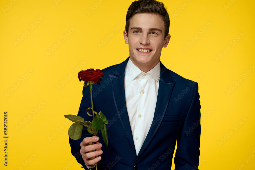 Gentleman in classic suit on yellow background with red rose romance 