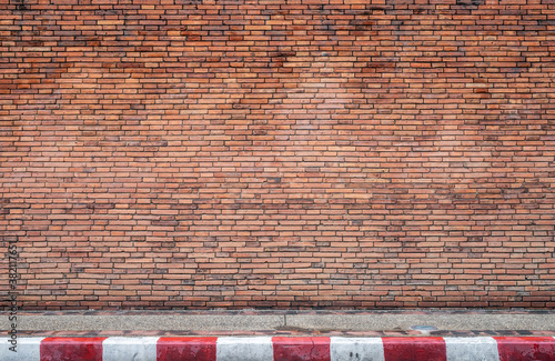 red brick wall texture grunge background With footpaths that prohibit parking photo