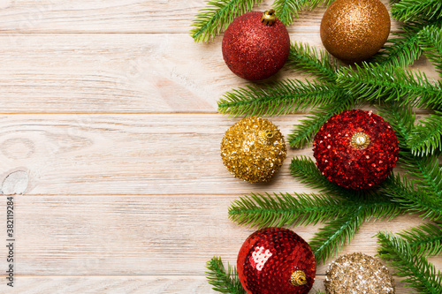 Set of festive balls, fir tree and Christmas decorations on wooden background. Top view of New Year ornament concept with copy space