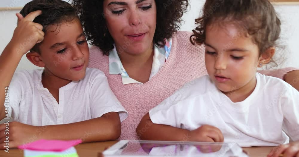 Mother using tablet with children at home - Family and technology concept Mother using tablet with children at home - Family and technology concept