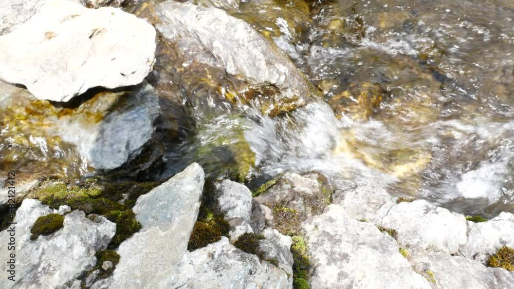 View of tranquil waters flowing in a mountain creek. Roks are visibile through crystalline water. View of tranquil waters flowing in a mountain creek. Roks are visibile through crystalline water.