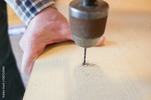 Obraz na płótnie man drilling a hole in wood with an old manual drill w salonie