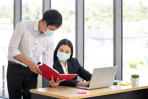 Office employee discuss their work with surgical mask for covid-19 outbreak prevention
