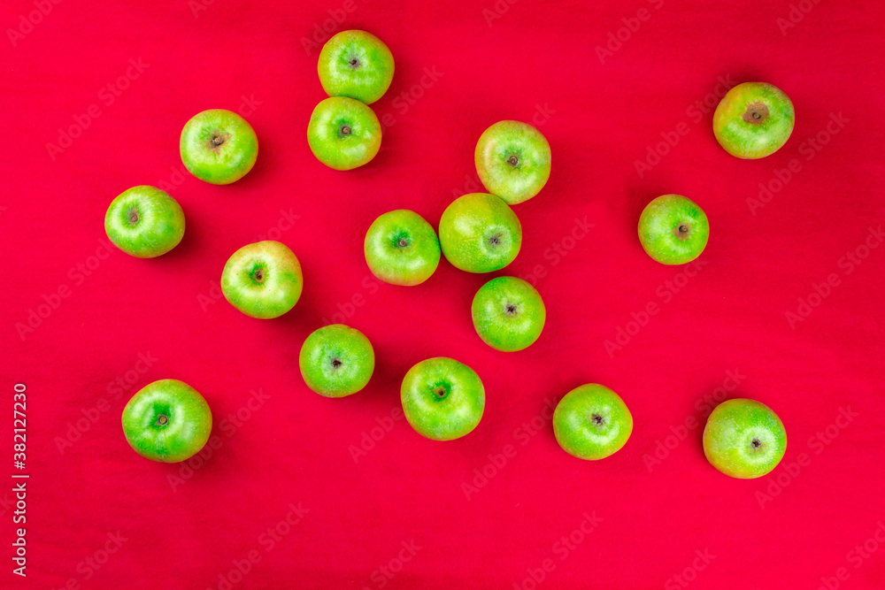 Green apples on a red background Green apples on a red background