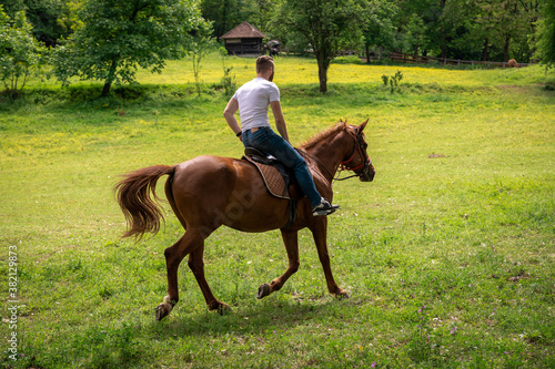 Young adult galloping on a horse at a ranch