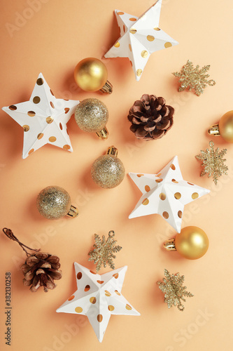 bella composición moderna de navidad en tonos dorados y naranjas con bambalinas piña de pino y estrellas de papel