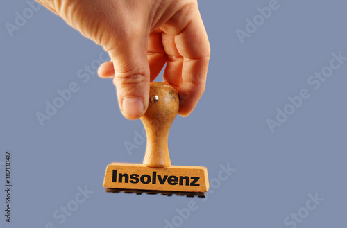 Insolvenz in engl bankcruptcy rubber stamp hand with blue background photo