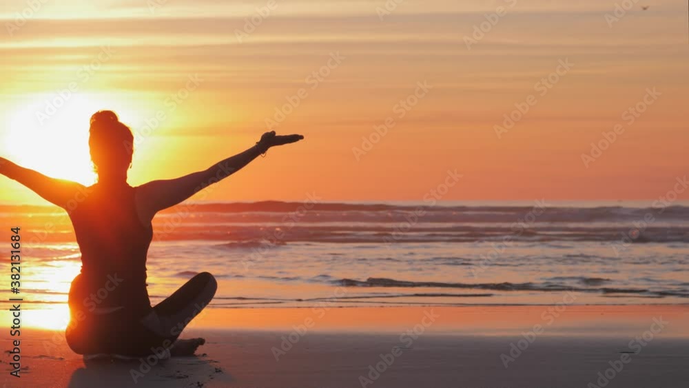 Silhouette of slim woman with arms raised up on the beach Silhouette of slim woman with arms raised up on the beach