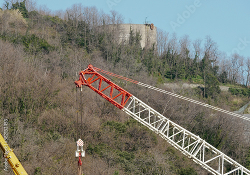 Il braccio meccanico di una gru semovente con un sistema di ingranaggi e carrucole all’apice.  photo