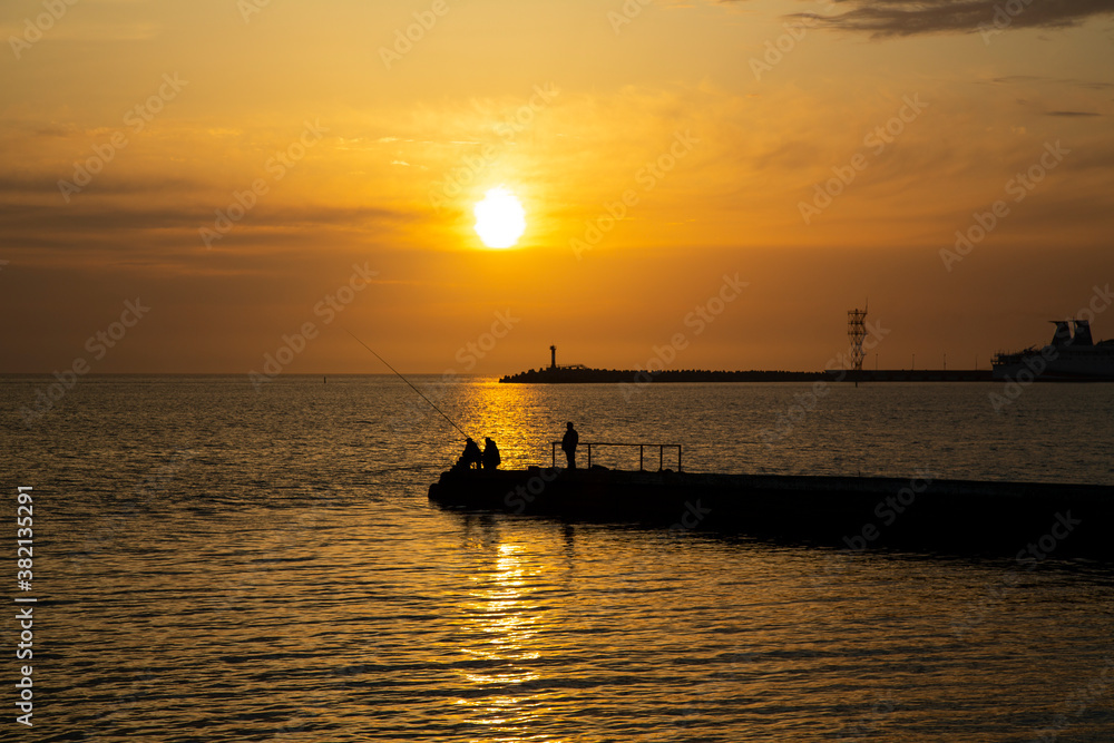 Fishing on the sea. Men fish in the evening at sunset